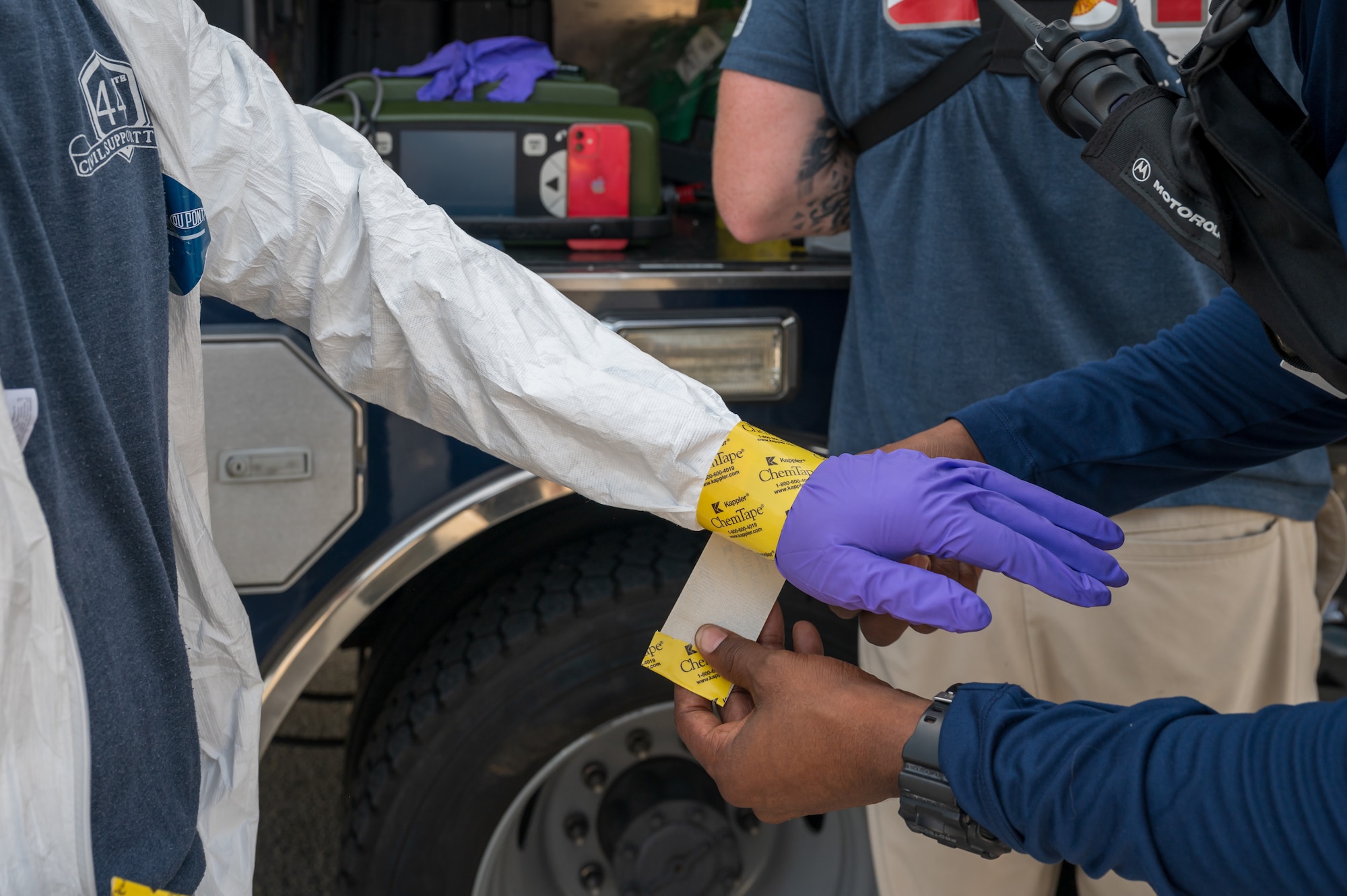 Space Launch Delta 45 Emergency Management personnel and members of the Florida National Guard’s 44th Weapons of Mass Destruction Civil Support Team conduct a joint hazardous materials response training exercise at Patrick Space Force Base, Fla., July 28, 2026. A team member seals protective gloves to a chemical-resistant suit before entering the simulated hazardous area, helping maintain the integrity of the responder’s personal protective equipment. (U.S. Space Force photo by Gwendolyn Kurzen)