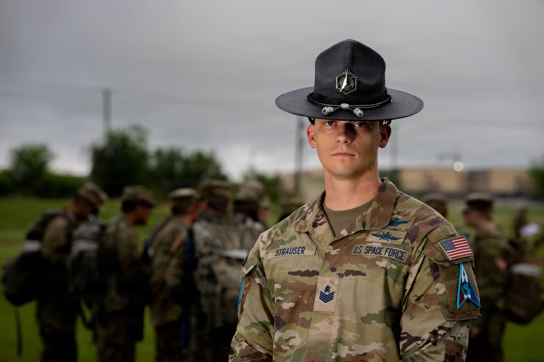 MTI in uniform outside with cadets behind him