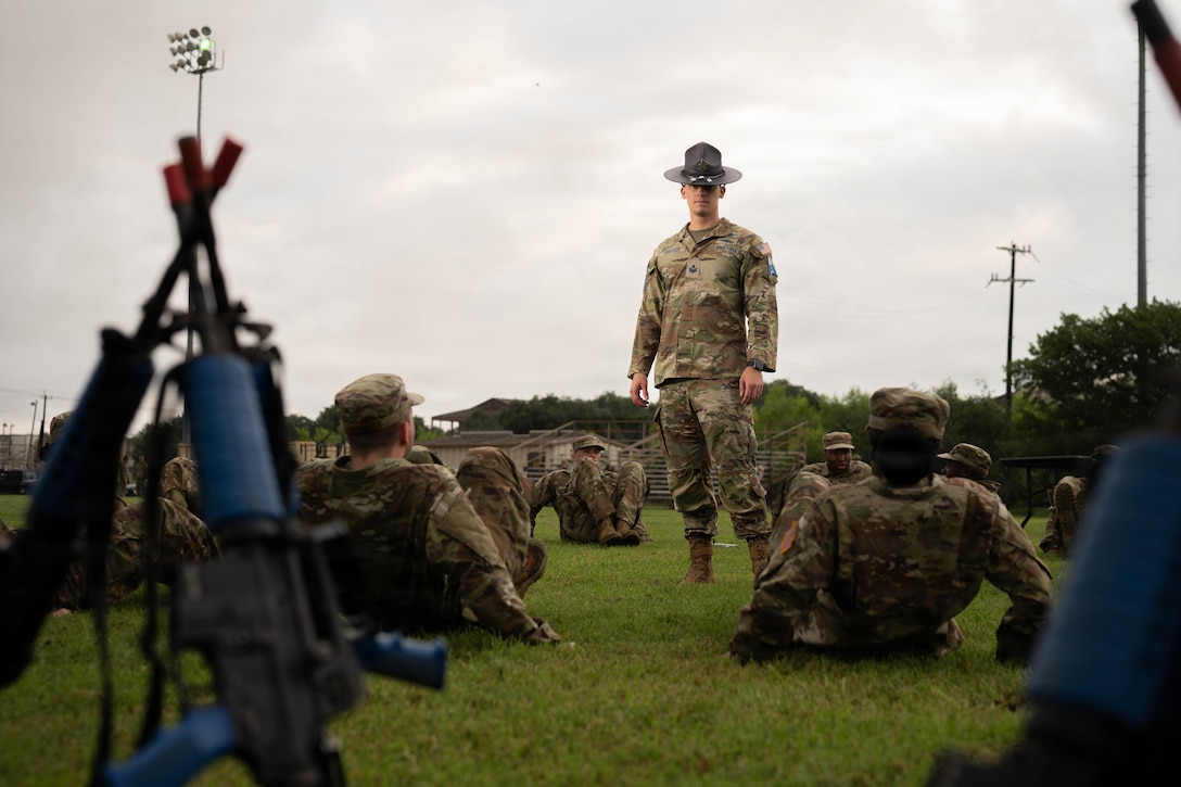 MTI outside in uniform with cadets working out in field