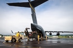 Hawaii Army National Guard Soldiers and Hawaii Air National Guard Airmen prepare to load a Hawaii Army National Guard UH-60M Black Hawk helicopter aboard a Hawaii Air National Guard C-17 Globemaster III assigned to the 204th Airlift Squadron at Hilo International Airport, July 31, 2026. The movement marked the first deployment of a Hawaii Army National Guard Black Hawk to the Philippines, launching an aviation engagement under the Department of War National Guard Bureau State Partnership Program between Hawaii and the Philippines and building on years of aviation exchanges between the two partner forces. Photo by Senior Master Sgt. Mysti Bicoy.