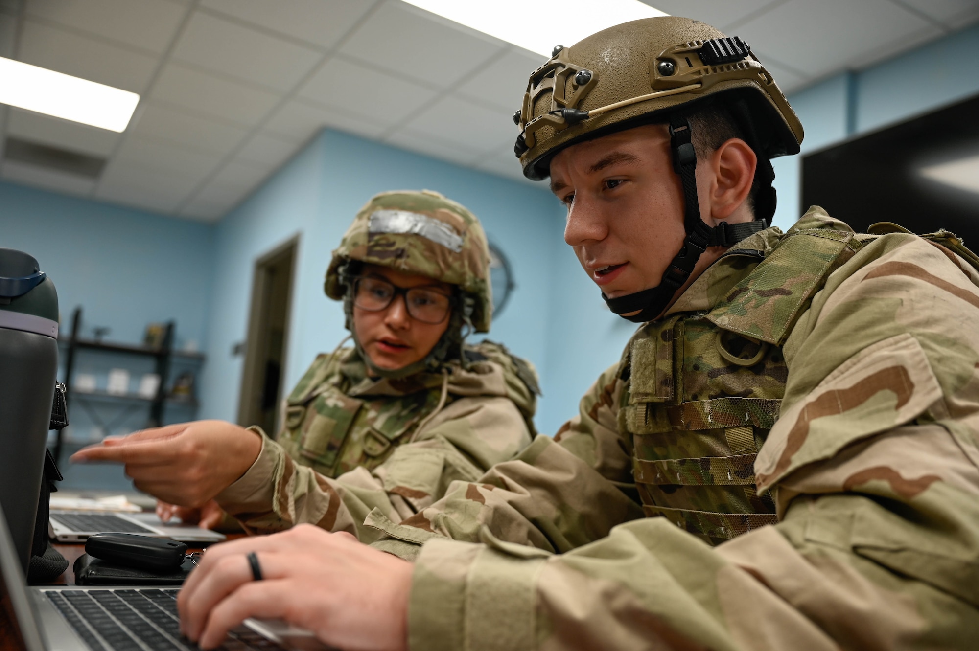 Two Airmen look at a computer