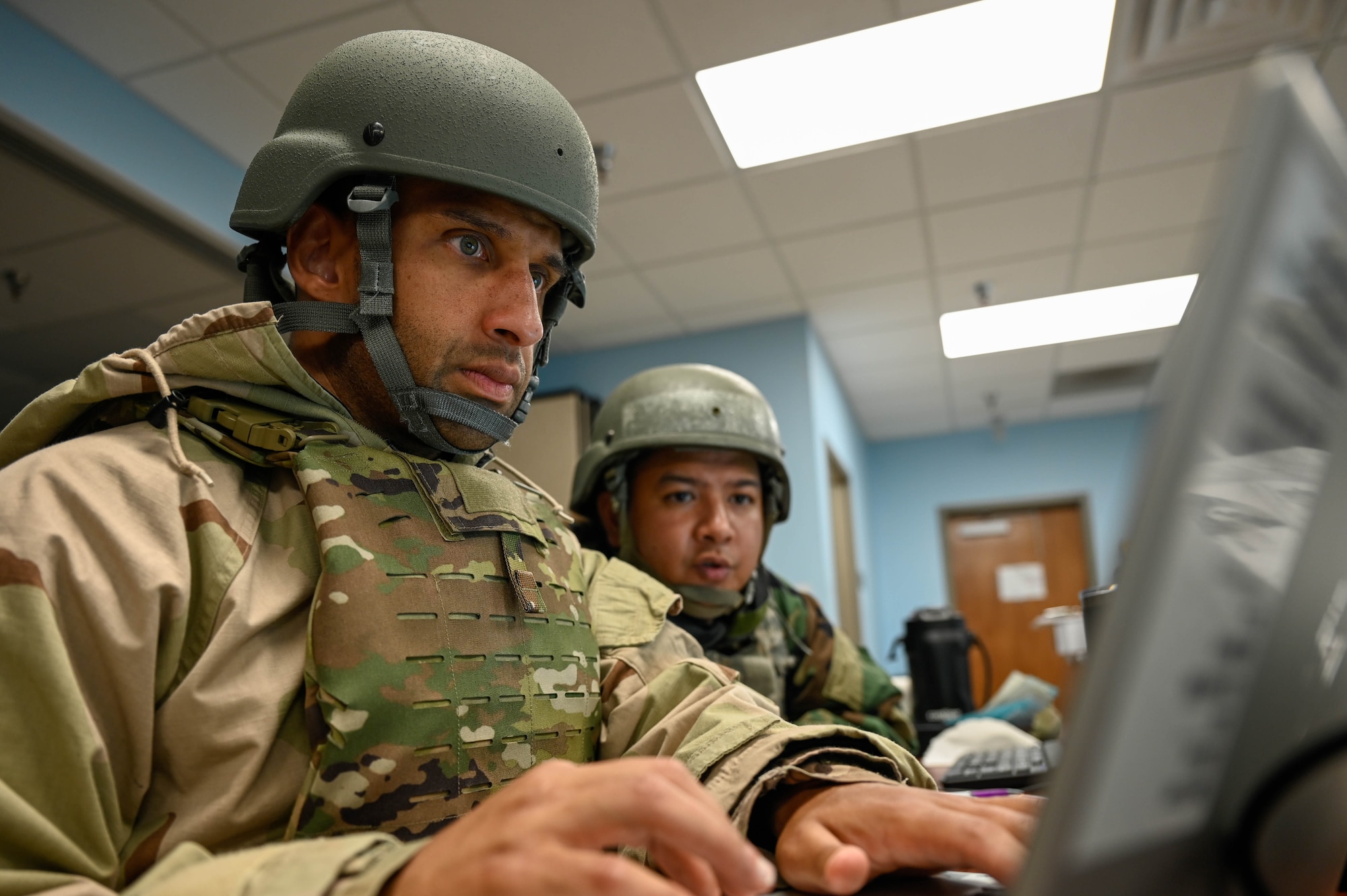 Two Airmen look at a computer