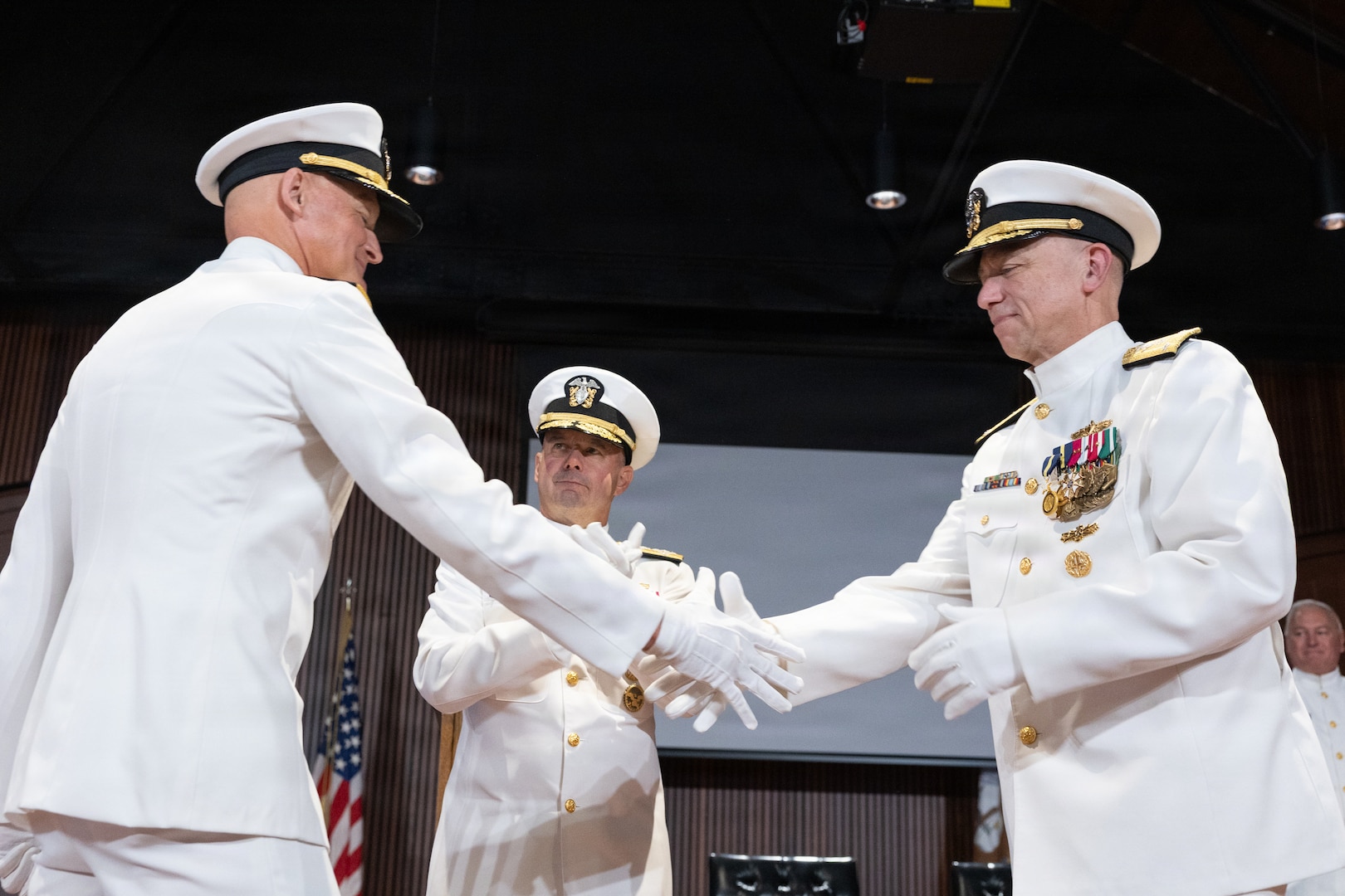 Rear Adm. Todd S. Weeks (left) shakes hands with Vice Adm. James P. Downey, commander, Naval Sea Systems Command (NAVSEA) and Portfolio Acquisition Executive Industrial Operations (PAE IO), as Adm. James W. Kilby, Vice Chief of Naval Operations looks on, during a joint change of office and command ceremony on the Washington Navy Yard, Aug. 6. Downey was relieved of his dual-hatted role as commander, NAVSEA by Rear Adm. Peter Small and as PAE IO by Weeks. (U.S. Navy photo by Matthew Rakola.)