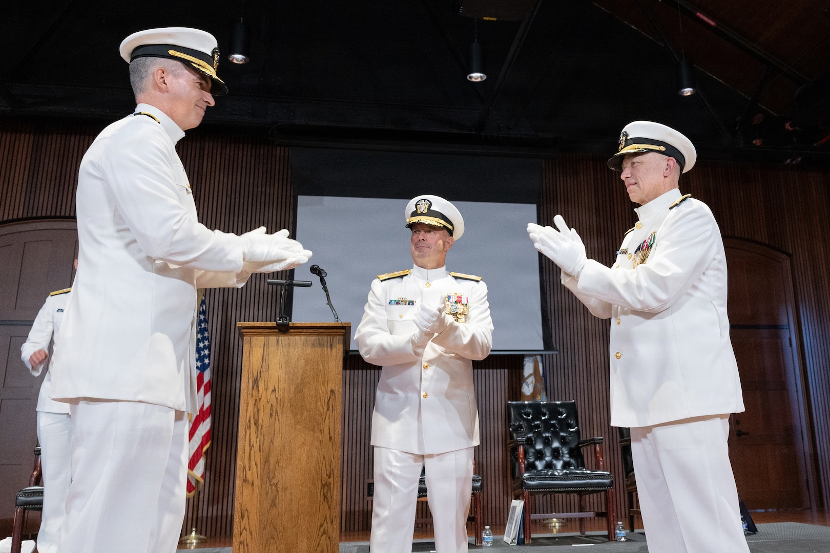 Rear Adm. Peter D. Small (left) with Adm. James W. Kilby, Vice Chief of Naval Operations (center) and Vice Adm. James P. Downey applaud during a joint change of office and command ceremony on the Washington Navy Yard, Aug. 6. Downey was relieved of his dual-hatted role as commander, Naval Sea Systems Command by Small and as Portfolio Acquisition Executive Industrial Operations by Rear Adm. Todd Weeks. (U.S. Navy photo by Matthew Rakola)
