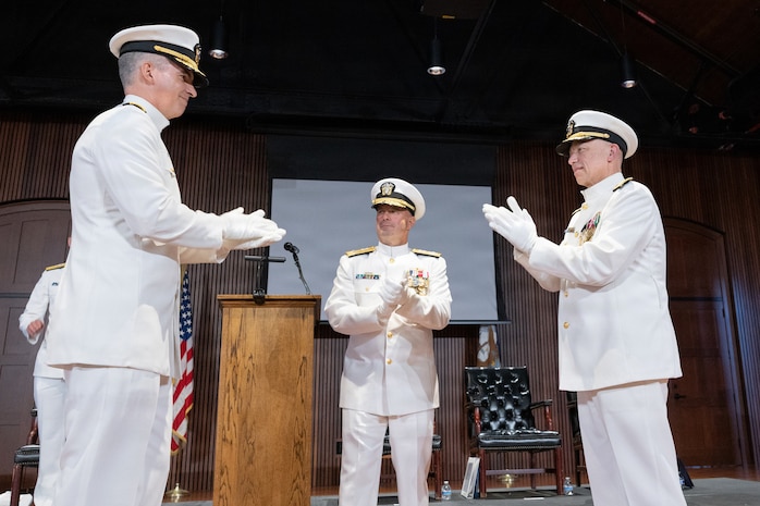 Rear Adm. Peter D. Small (left) with Adm. James W. Kilby, Vice Chief of Naval Operations (center) and Vice Adm. James P. Downey applaud during a joint change of office and command ceremony on the Washington Navy Yard, Aug. 6. Downey was relieved of his dual-hatted role as commander, Naval Sea Systems Command by Small and as Portfolio Acquisition Executive Industrial Operations by Rear Adm. Todd Weeks. (U.S. Navy photo by Matthew Rakola)