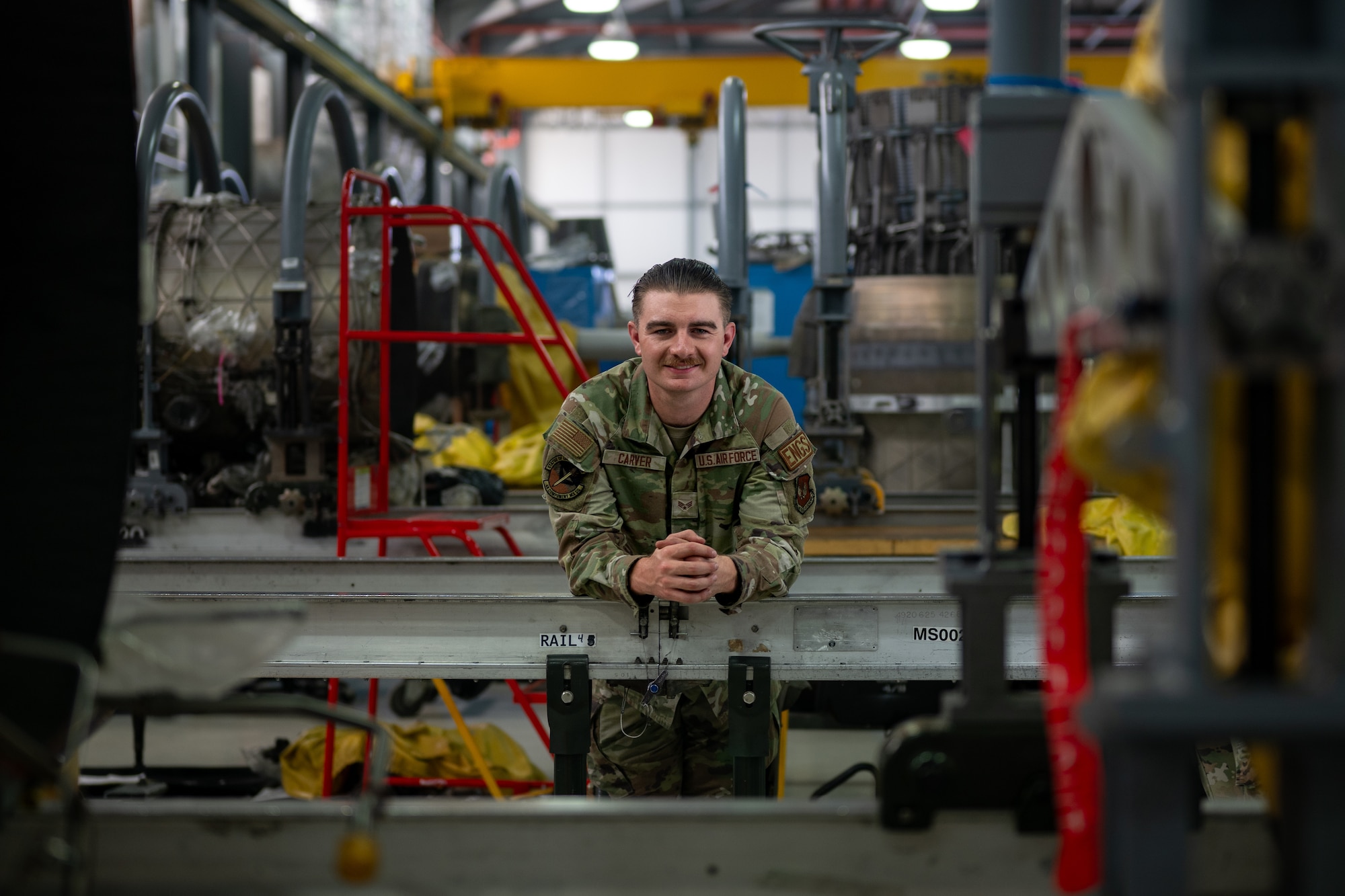 A military member leans against equipment