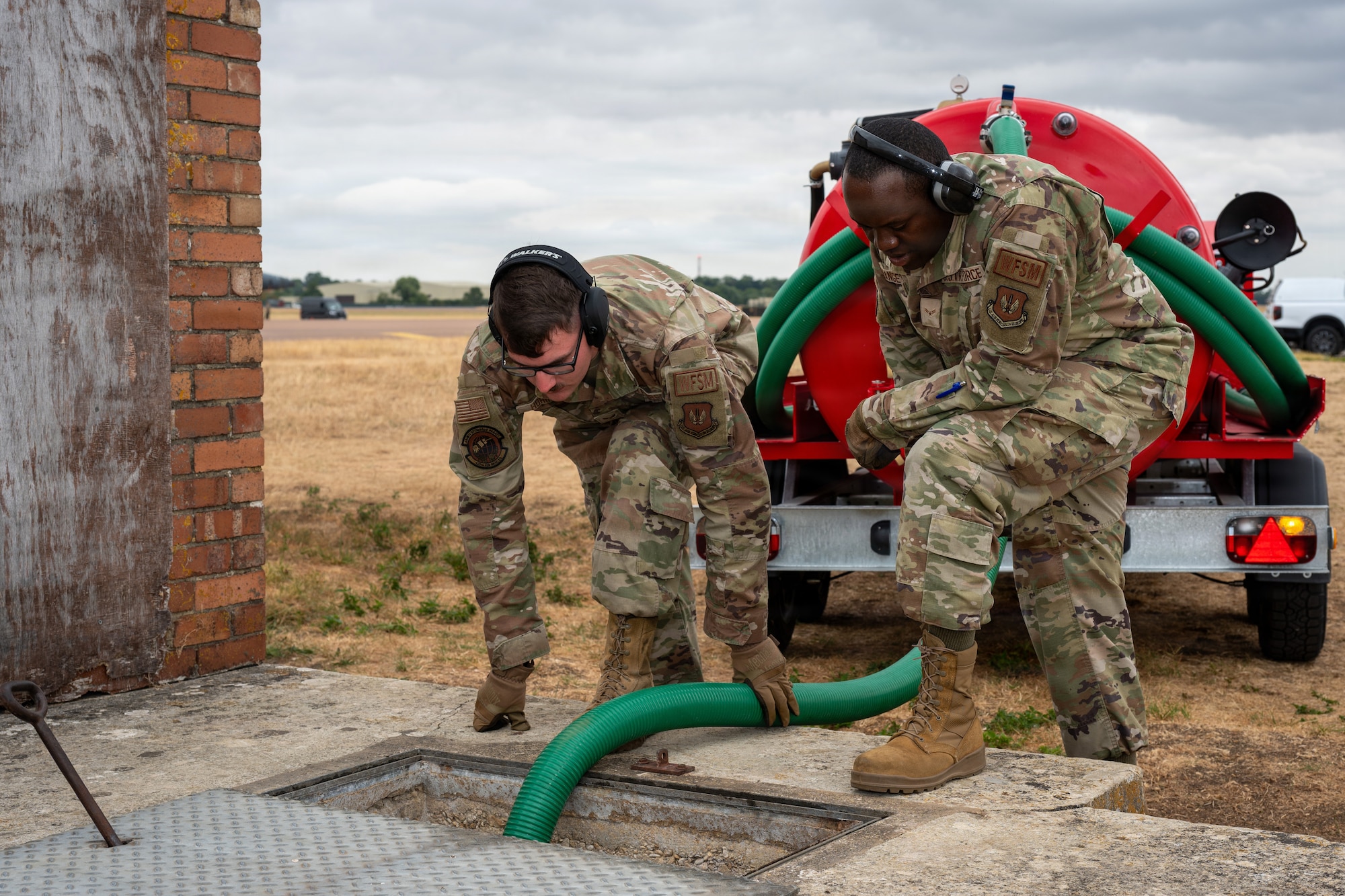 Pathfinders position a hose during waste-removal operations at RAF Fairford, England, Aug. 4, 2026. Routine maintenance keeps critical equipment operational and ready to support the mission. (U.S. Air Force photo by SrA Adam Enbal)