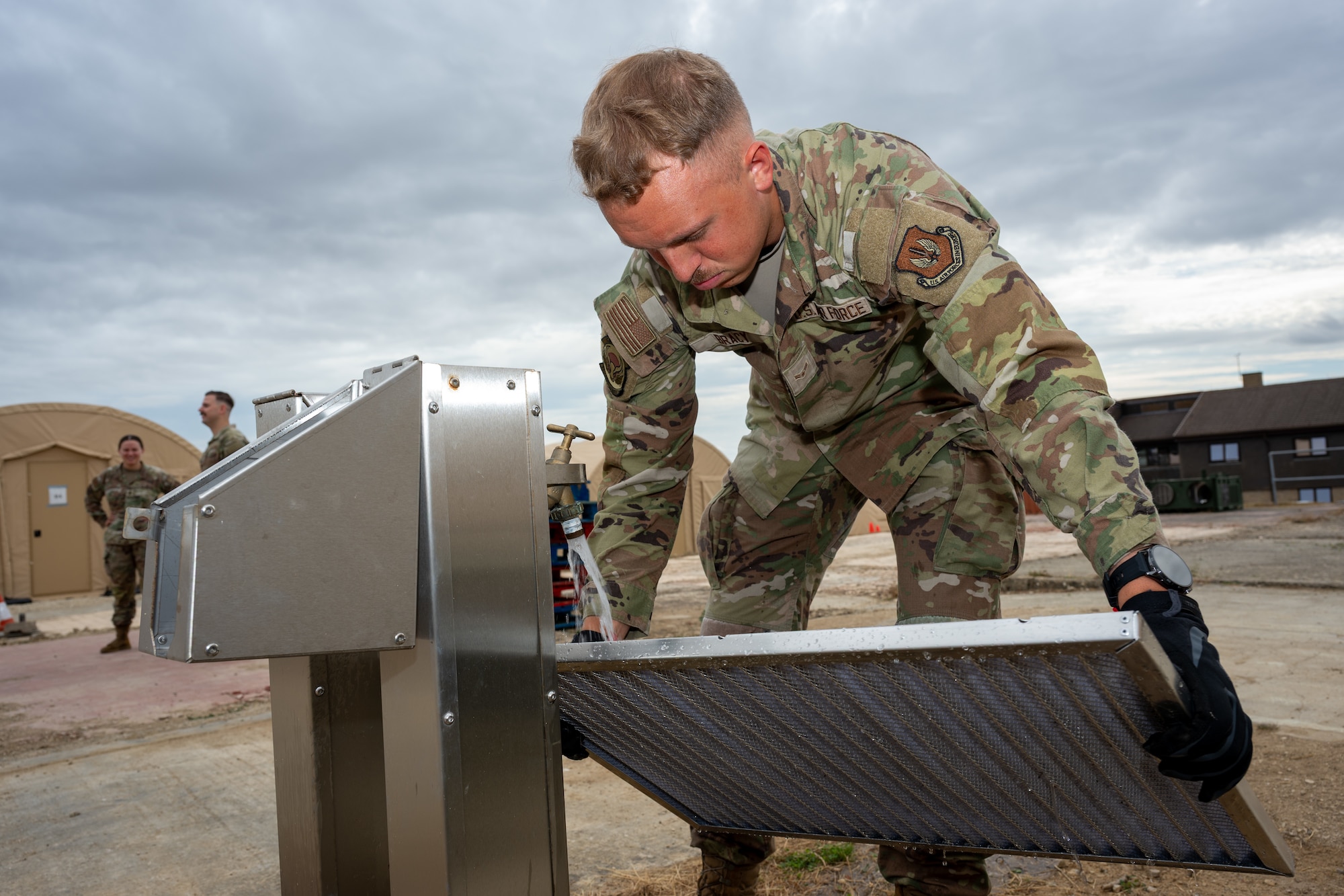 U.S. Air Force Airman 1st Class Dylan Bracy, 420th Air Base Squadron heating, ventilation, air conditioning and refrigeration technician, cleans an air-conditioning unit filter during preventive maintenance at RAF Fairford, England, Aug. 4, 2026. Routine maintenance keeps critical equipment operational and ready to support the mission. (U.S. Air Force photo by SrA Adam Enbal)