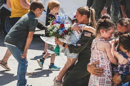 Recently deployed Airmen hug their families after returning to Bangor Air National Guard Base, Maine, July 27, 2026. The Airmen returned home following a routine deployment to an undisclosed location in Europe. (U.S. Air Force photo by Senior Master Sgt. Andrew Sinclair)