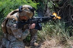 U.S. Air Force Senior Airman Christopher Figueroa, Colorado National Guard 140th Security Forces Squadron, or SFS, security forces specialist, fires at opposition forces during Operation Iron Flag, a hands-on, combat simulation field exercise June 17, 2026, at Bellows Air Force Station, Hawaii. The 140th SFS implemented jungle warfare movements, land navigation and nonverbal signals as part of their annual training. Photo by Senior Airman Eliana Raspet.