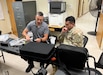 Matthew Hernandez, an electronics technician with U.S. Army Medical Logistics Command, shows Sgt. Cristian Nunez, a biomedical equipment specialist (68A) for Charlie Company, 299th Brigade Support Battalion, 2nd Armor Brigade Combat Team, 1st Infantry Division, how to perform maintenance on a ventilator during one-on-one training at Fort Riley, Kansas. Hernandez and another flyaway team member from AMLC’s Medical Maintenance Operations Division in Utah performed pre-deployment maintenance on nearly 130 medical devices during the visit over two weeks in July.