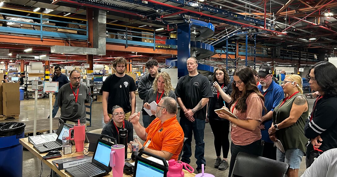 a group of people work inside of a large warehouse.