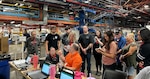 a group of people work inside of a large warehouse.