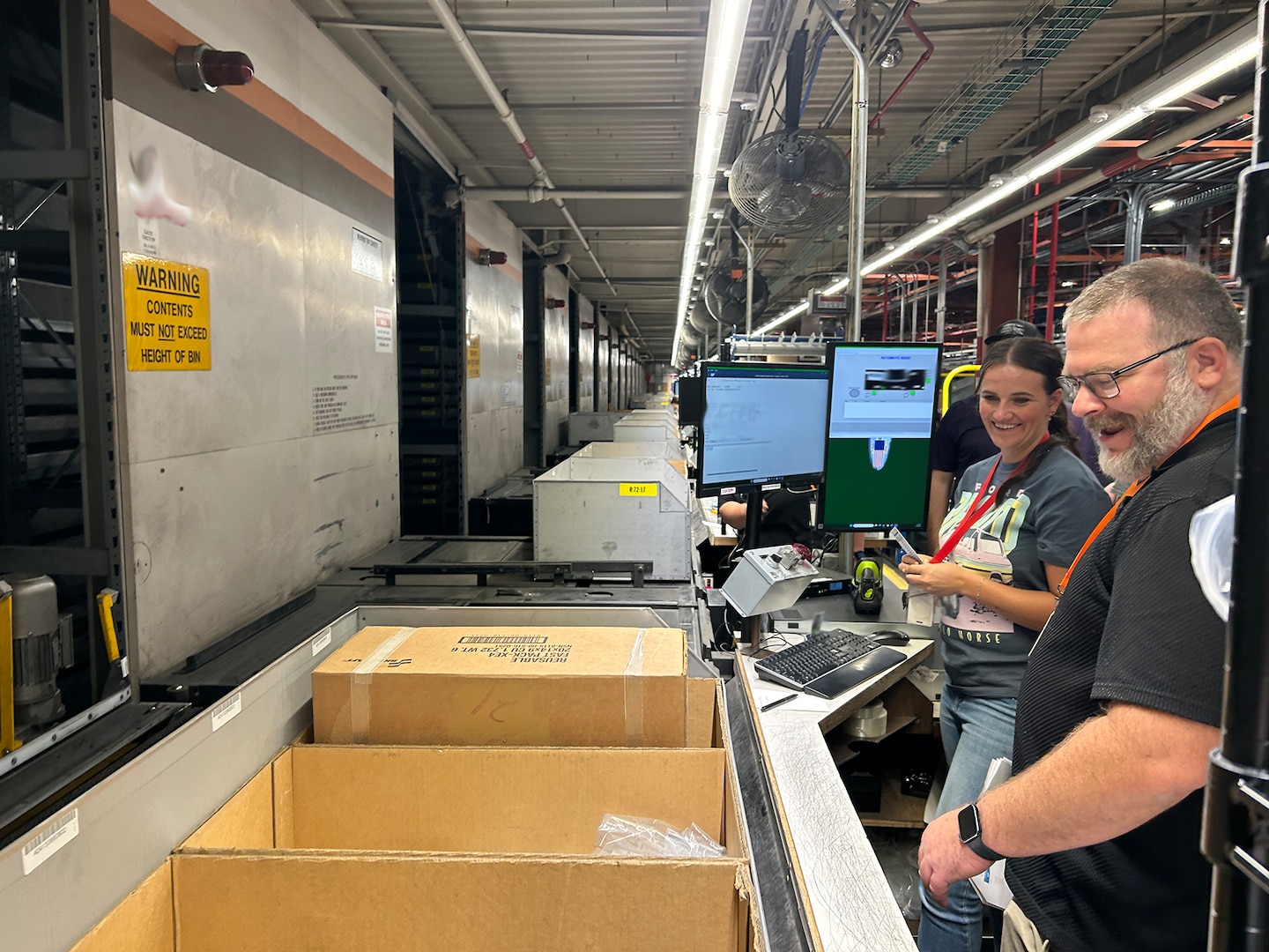 people working inside a warehouse look into boxes.