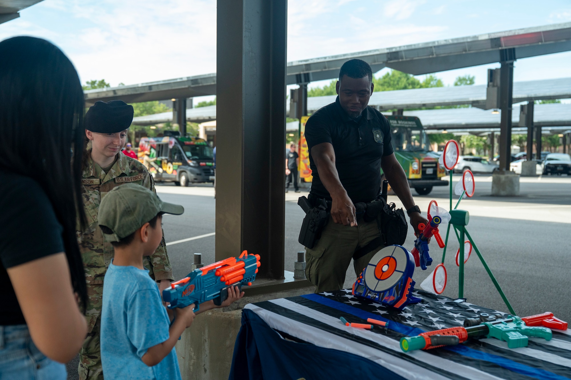 DIA Sgt points at a Nerf bullseye to show a child where to aim his nerf weapon