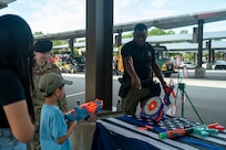 DIA Sgt points at a Nerf bullseye to show a child where to aim his nerf weapon