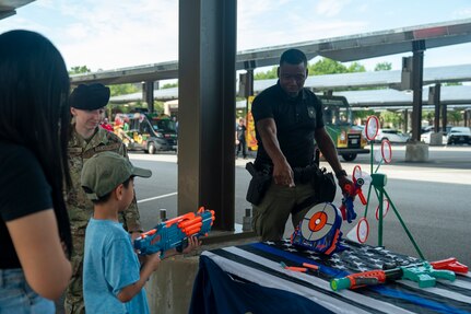 DIA Sgt points at a Nerf bullseye to show a child where to aim his nerf weapon
