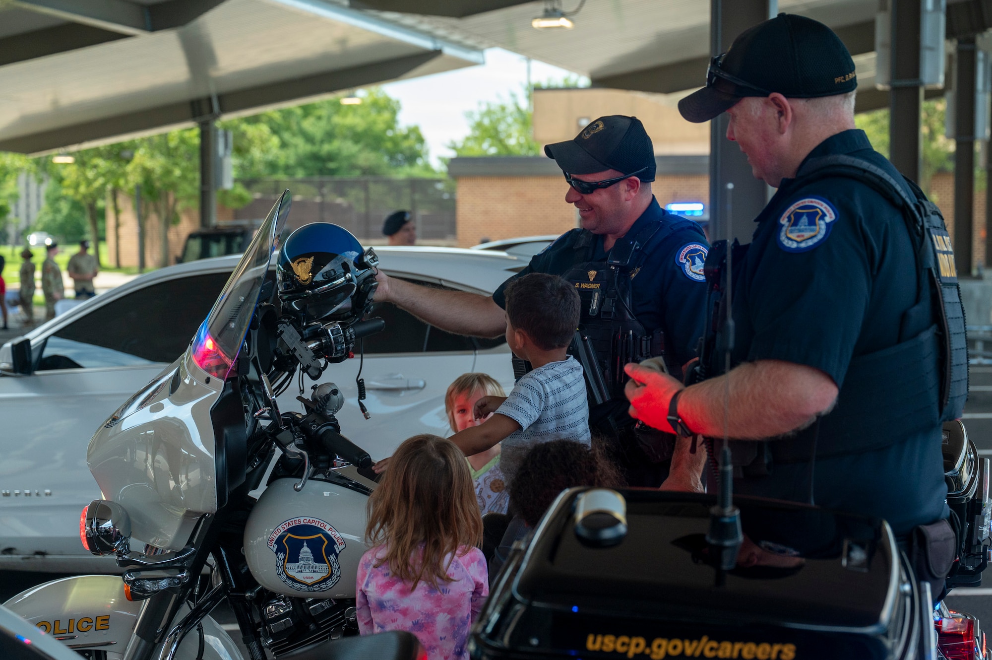 U.S. Capitol Police motor officers help children sit on their motorcycles
