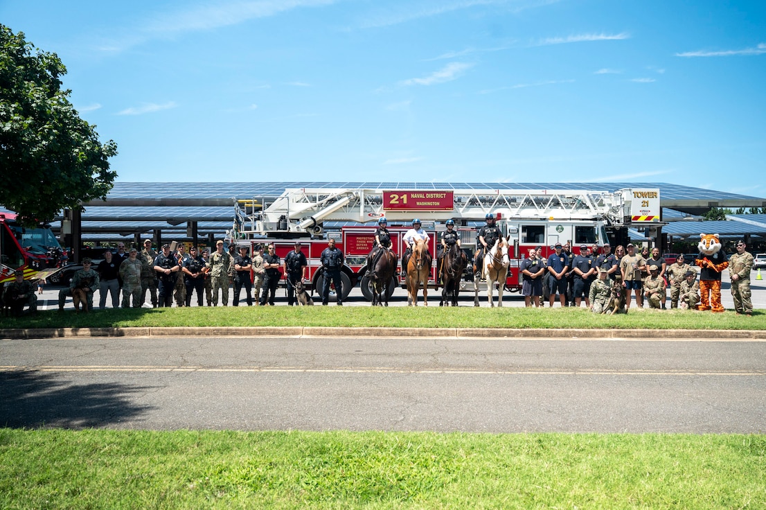 Representatives from local and federal agencies pose for a group photo in front of a fire truck