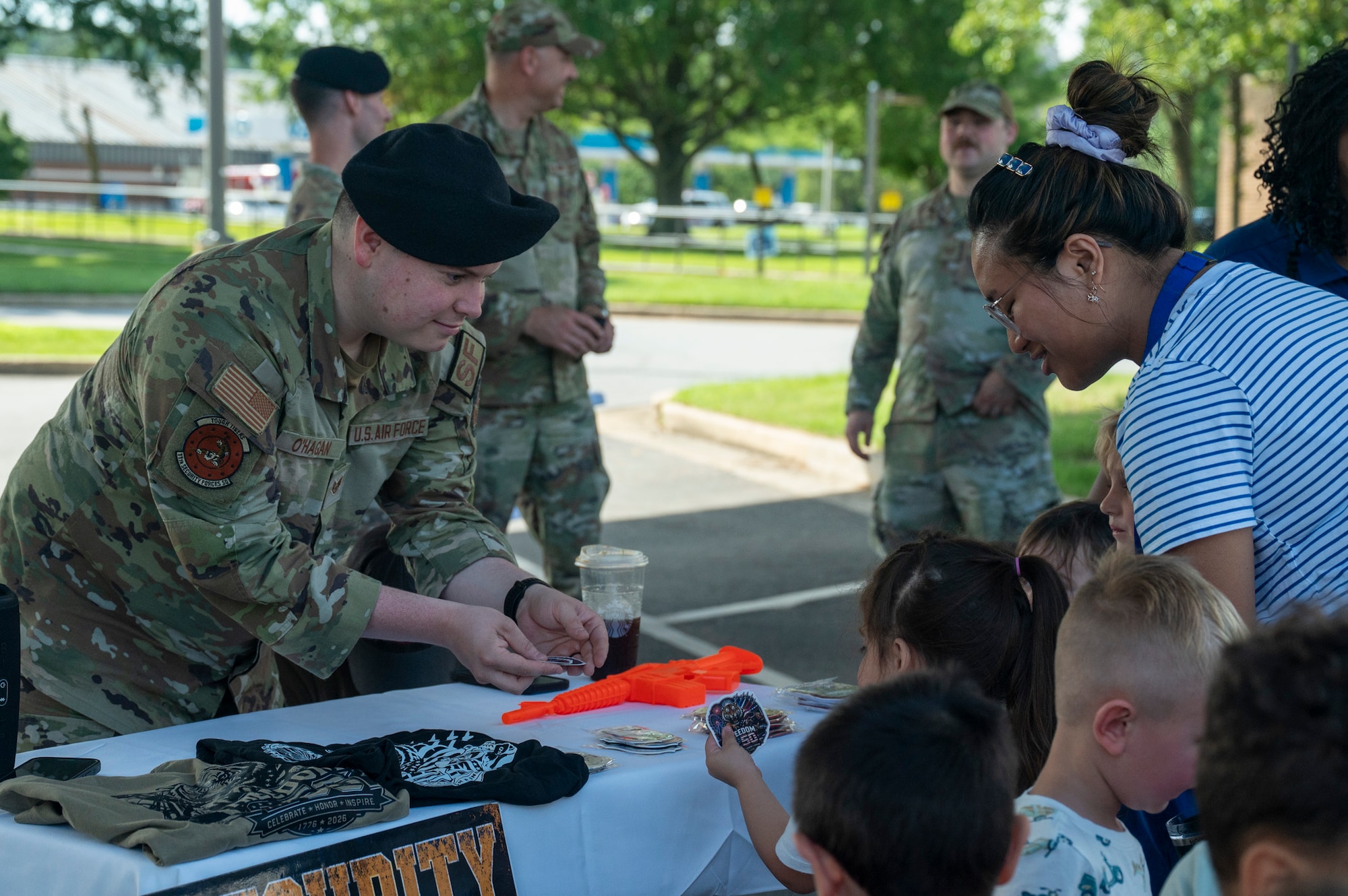 Security Forces officer hands stickers to children
