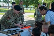 Security Forces officer hands stickers to children