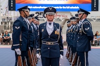 U.S. Air Force Master Sgt stands in the center of a honor guard drill team