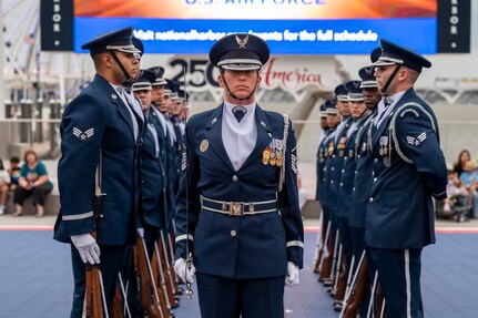 U.S. Air Force Master Sgt stands in the center of a honor guard drill team