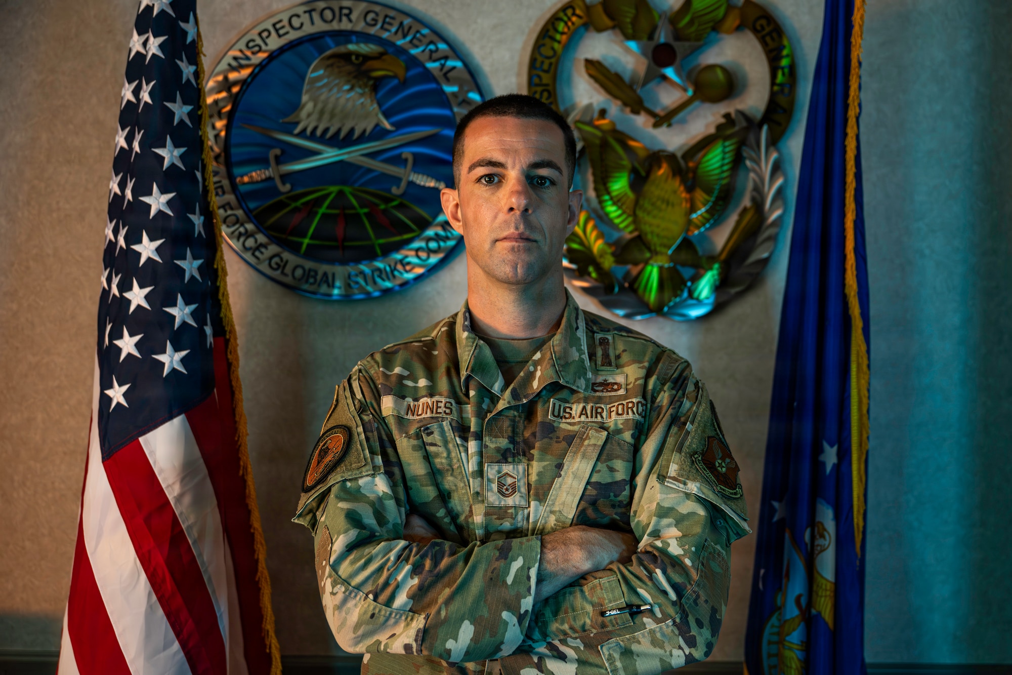U.S. Air Force Master Sgt. Pete Nunes, Air Force Global Strike Command  B-2 armament inspector, poses in front of AFGSC inspector general signs at Barksdale Air Force Base, Louisiana, Aug. 4, 2026. Nunes evaluates nuclear and conventional weapons operations to ensure units meet the Air Force's highest standards. (U.S. Air Force photo by Senior Airman Rhea Beil)