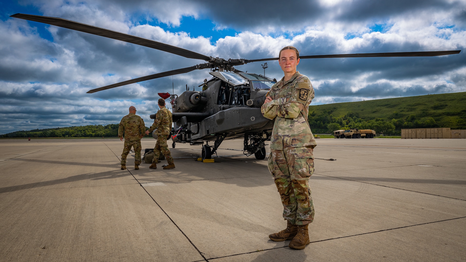 FORT RILEY, Kan. — Army ROTC Cadet Claire Troshynski, a nursing student from Texas Christian University, poses in front of an AH-64 Apache helicopter at Marshall Army Airfield, July 31. Troshynski, whose career goal is to become an Enroute Critical Care Nurse, toured the airfield alongside other cadets participating in the four-week Nurse Summer Training Program (NSTP) at Irwin Army Community Hospital. Following the ground tour, the cadets took a familiarization flight in a UH-60 Blackhawk helicopter over the Kansas Flint Hills to experience the environment of Army aviation and airborne medical transport.