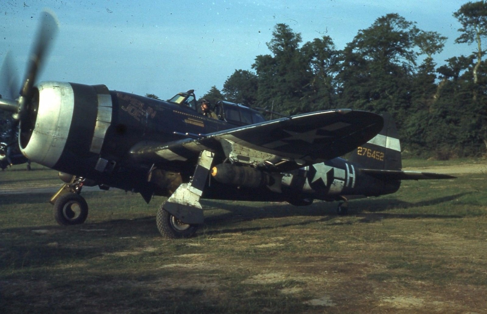 Republic P-47D-20-RE Thunderbolt serial number 42-76452 of the 405th Fighter Squadron, 371st Fighter Group in France prepares to takeoff on a combat mission during 1944.  Note the 500-lb bombs underneath the wings.  It is a near serial number to the Thunderbolt which Lt. Pollingue flew on his fatal mission, P-47D-20-RE serial number 42-76435.  (Via Capt. Tom Silkowski, 190th Fighter Squadron, Idaho ANG)