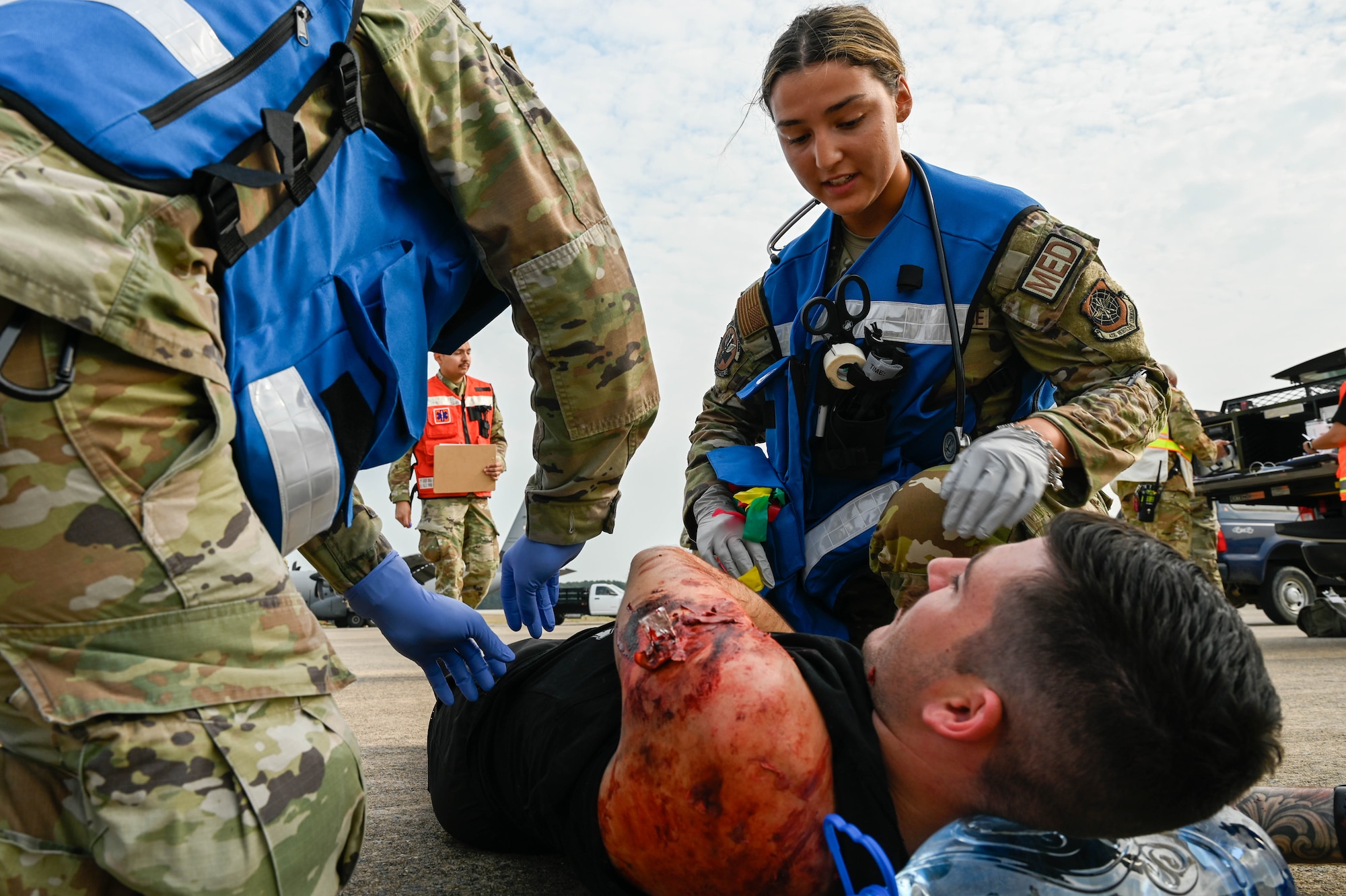 Airmen check over a simulated injured casualty.