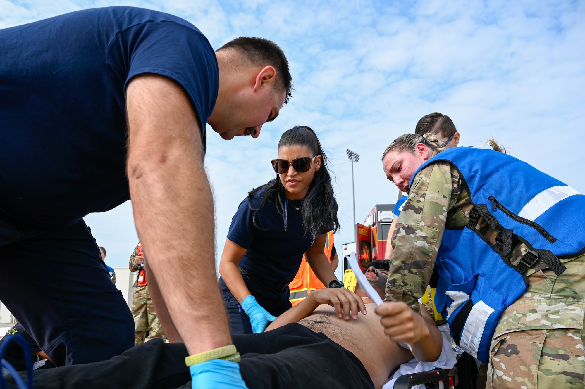 People are putting a simulated casualty on a litter.