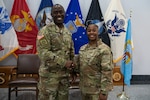 two people wearing camouflage military uniforms shake hands