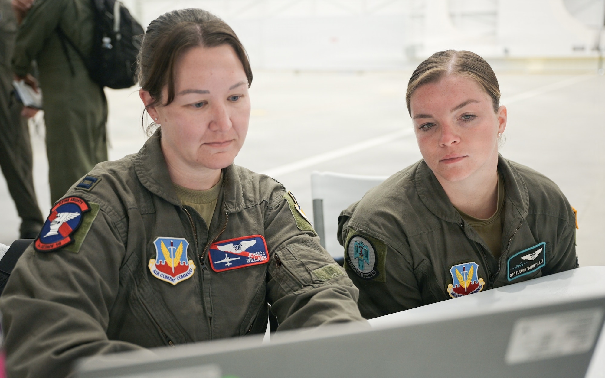 U.S. Air Force Capt. Jessica Williams, 9th Attack Squadron instructor pilot, left, and Staff Sgt. Jonie Lilly, 29th ATKS instructor sensor operator, review pre-launch data at Alpena Combat Readiness Training Center, Michigan, July 20, 2026.