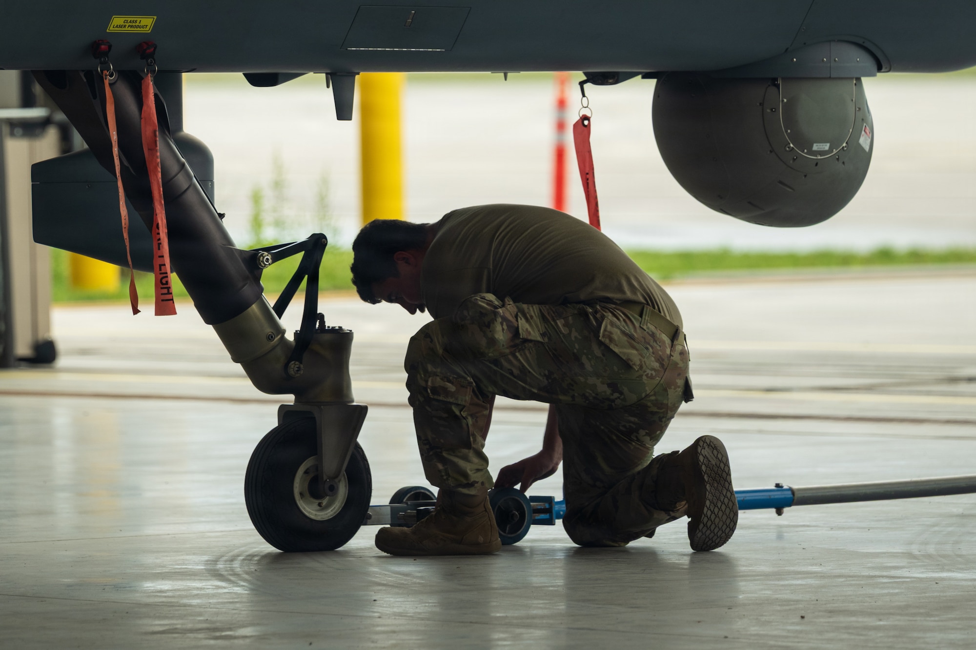 U.S. Air Force Senior Airman Samuel Melendrez, 9th Aircraft Maintenance Unit assistant dedicated crew chief, works with a tow bar under an MQ-9 Reaper at Alpena Combat Readiness Training Center, Michigan, July 21, 2026.