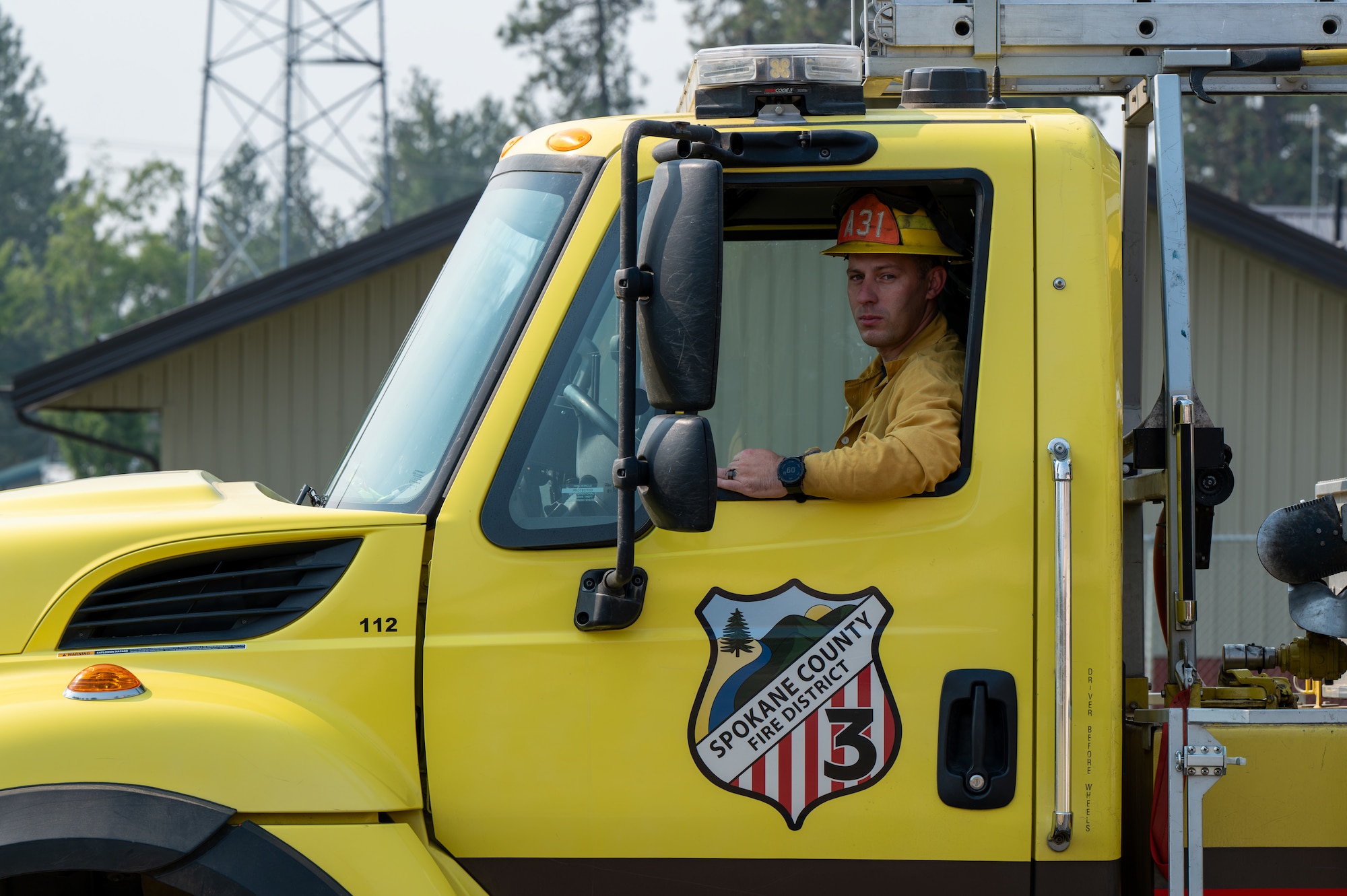 U.S. Air Force Master Sgt. Eric McNair, 92nd Operations Group first sergeant, sits in an attack firefighting apparatus used for brush fires at Spokane County Fire District #3, Cheney, Washington, Aug. 5, 2026. Responding to emergencies as a volunteer firefighter helps protect the local community while demonstrating the commitment to service that supports military readiness. (U.S. Air Force photo by Airman Audie Curtis)