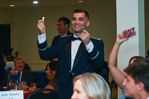 U.S. Air Force 2nd Lt. Paul Roberts, 47th Student Squadron student pilot, holds up his broken silver wings during the graduation ceremony of Class 26-15 at Laughlin Air Force Base, Texas, Aug. 6, 2026. The breaking of silver wings is a tradition dating back to the U.S. Army Air Corps, where a pilot's first wings are not to be worn but broken and given to a loved one. (U.S. Air Force photo by Airman 1st Class Kylie Rabb)