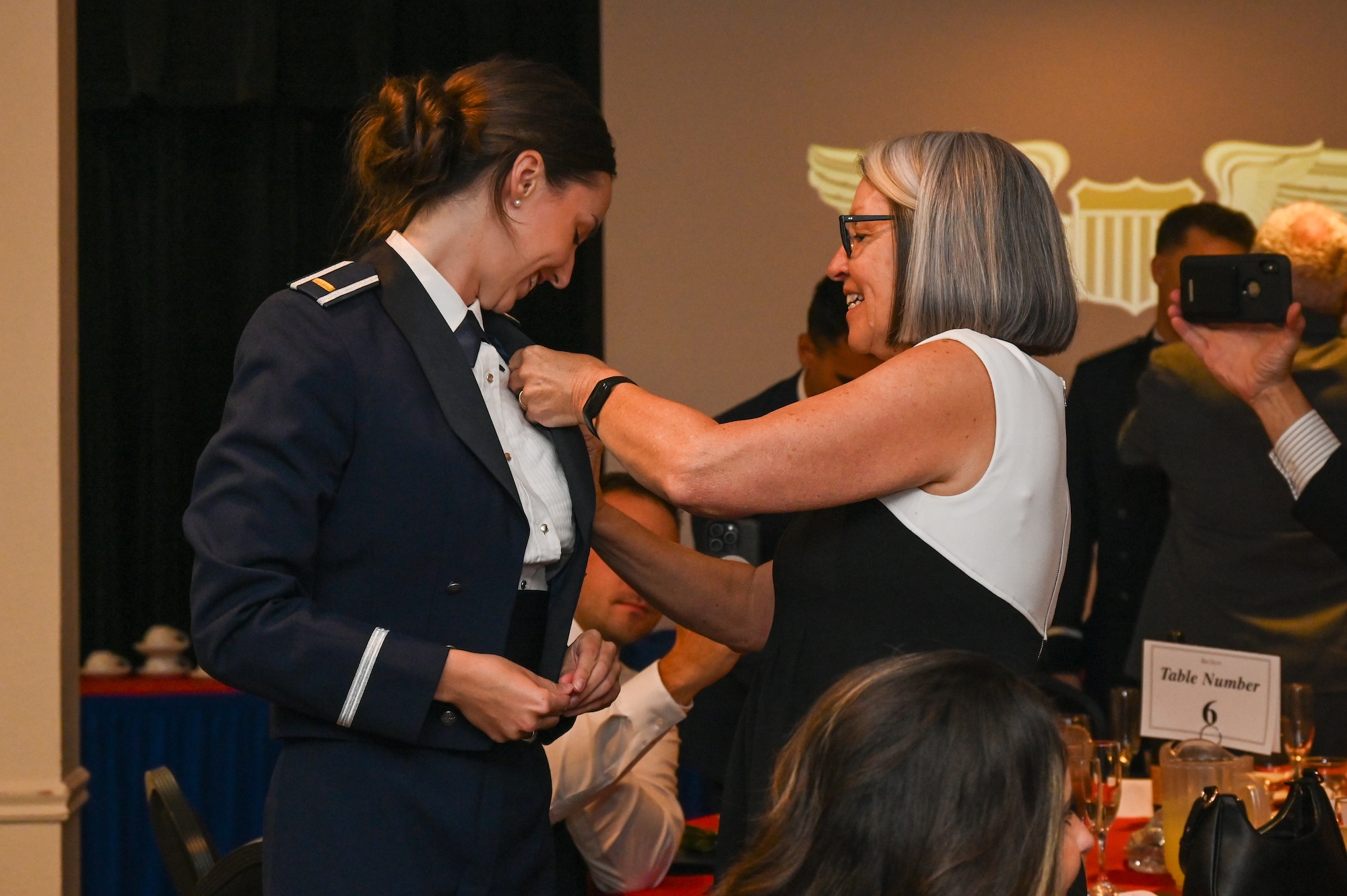 U.S. Air Force 2nd Lt. Elise Eichhorn, 47th Student Squadron student pilot, receives her silver wings with assistance from her guest during the graduation ceremony of Class 26-15 at Laughlin Air Force Base, Texas, August 6, 2026. Aviation wings are issued to pilots who have achieved a certain level of proficiency and training, and are a symbol of hard work, training, and dedication. (U.S. Air Force photo by Airman 1st Class Kylie Rabb)