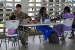 A U.S. Army Medic (left) works with a member of Panama's Ministerio de Salud (right) to take vitals of patients (far left and far right) during an exercise in Colon, Panama