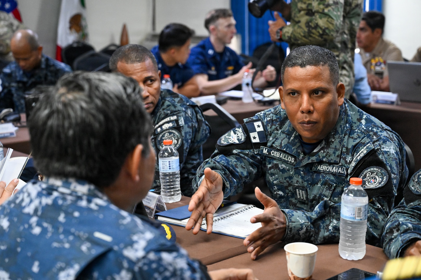 A Panamanian National Aeronaval Service commanding officer speaks with Mexican navy sailors