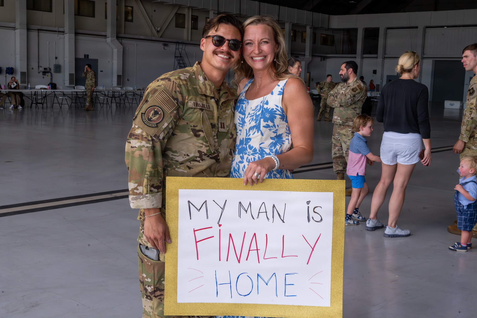 U.S. Air Force Capt. Zachary Trujillo, 50th Air Refueling Squadron aircraft commander, poses for a photo with his wife during a redeployment at MacDill Air Force Base, Florida, July 2, 2026. Families gathered inside the hangar to welcome home deployed Airmen. (U.S. Air Force photo by Airman Micquill Davis)