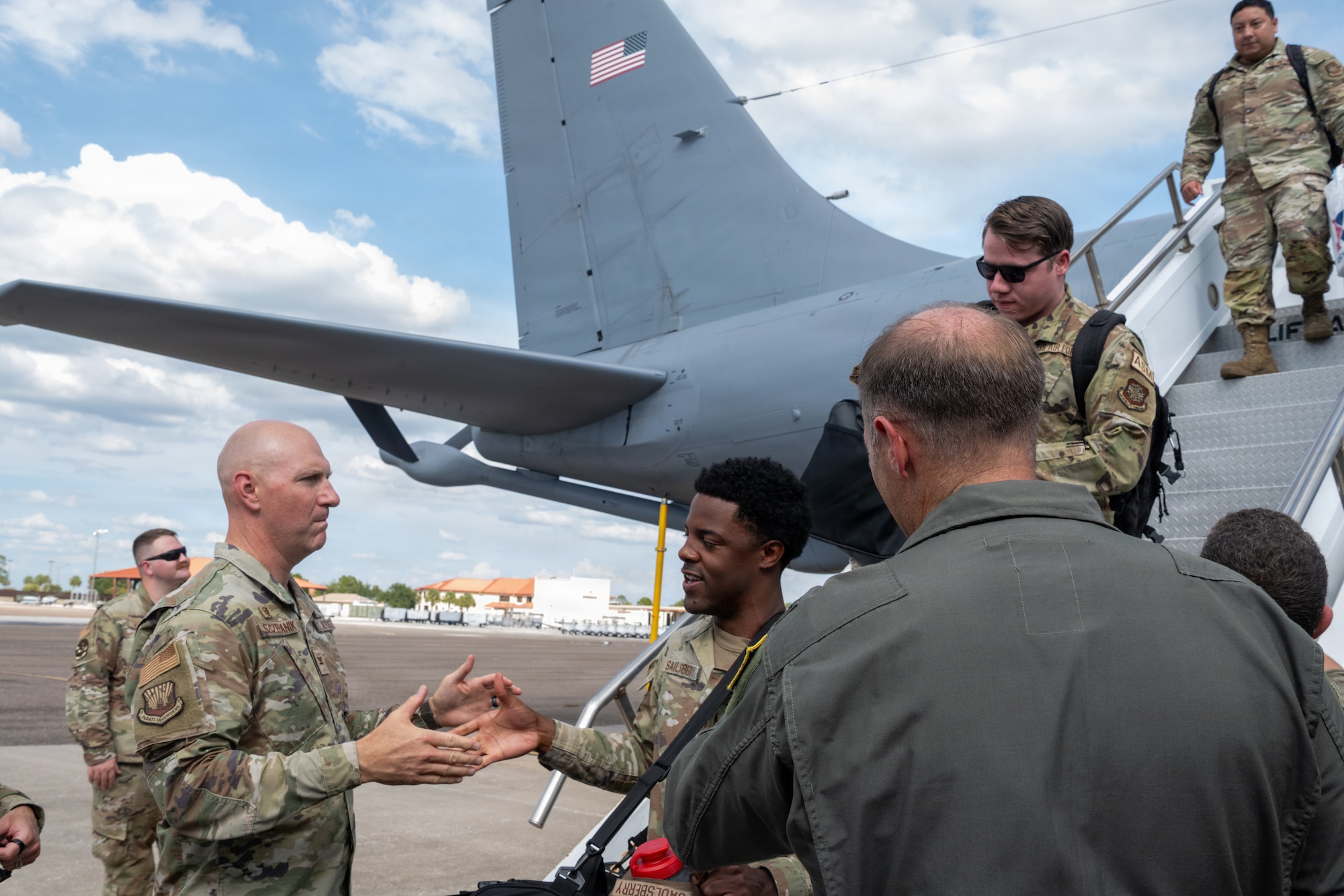 U.S. Air Force Col. Edward Szczepanik, 6th Air Refueling Wing commander, left, and Col. Keaton Askew, 6th ARW deputy commander, right, greet returning Airmen during a redeployment at MacDill Air Force Base, Florida, July 2, 2026. Leadership welcomed the Airmen home and thanked them for their service and sacrifice. (U.S. Air Force photo by Airman Micquill Davis)