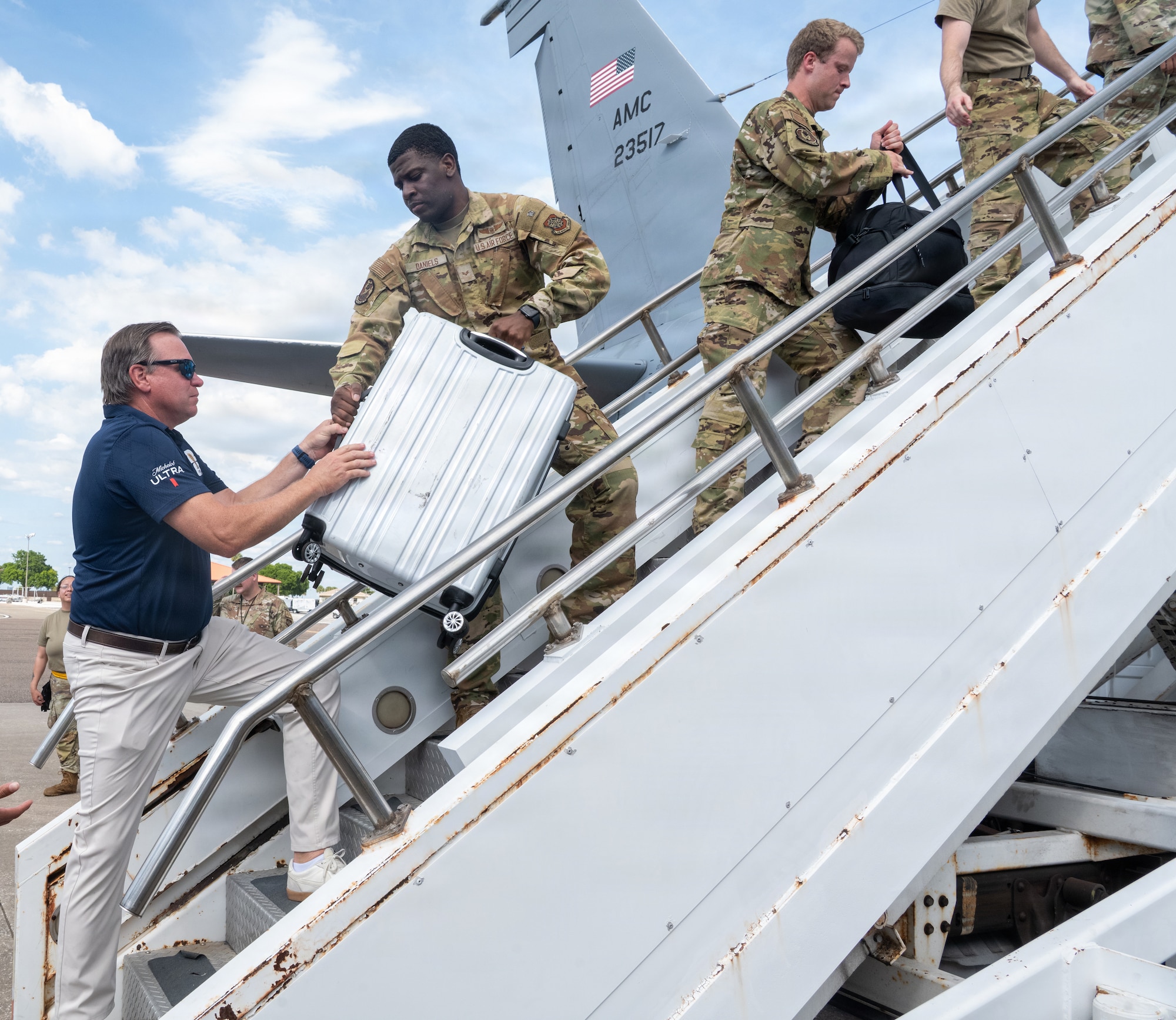 Greg McLeod, left, Pepin Distributing Company president, helps unload returning Airmen luggage during a redeployment at MacDill Air Force Base, Florida, July 2, 2026. Volunteers and Airmen assisted with unloading baggage for the returning Airmen. (U.S. Air Force photo by Airman Micquill Davis)