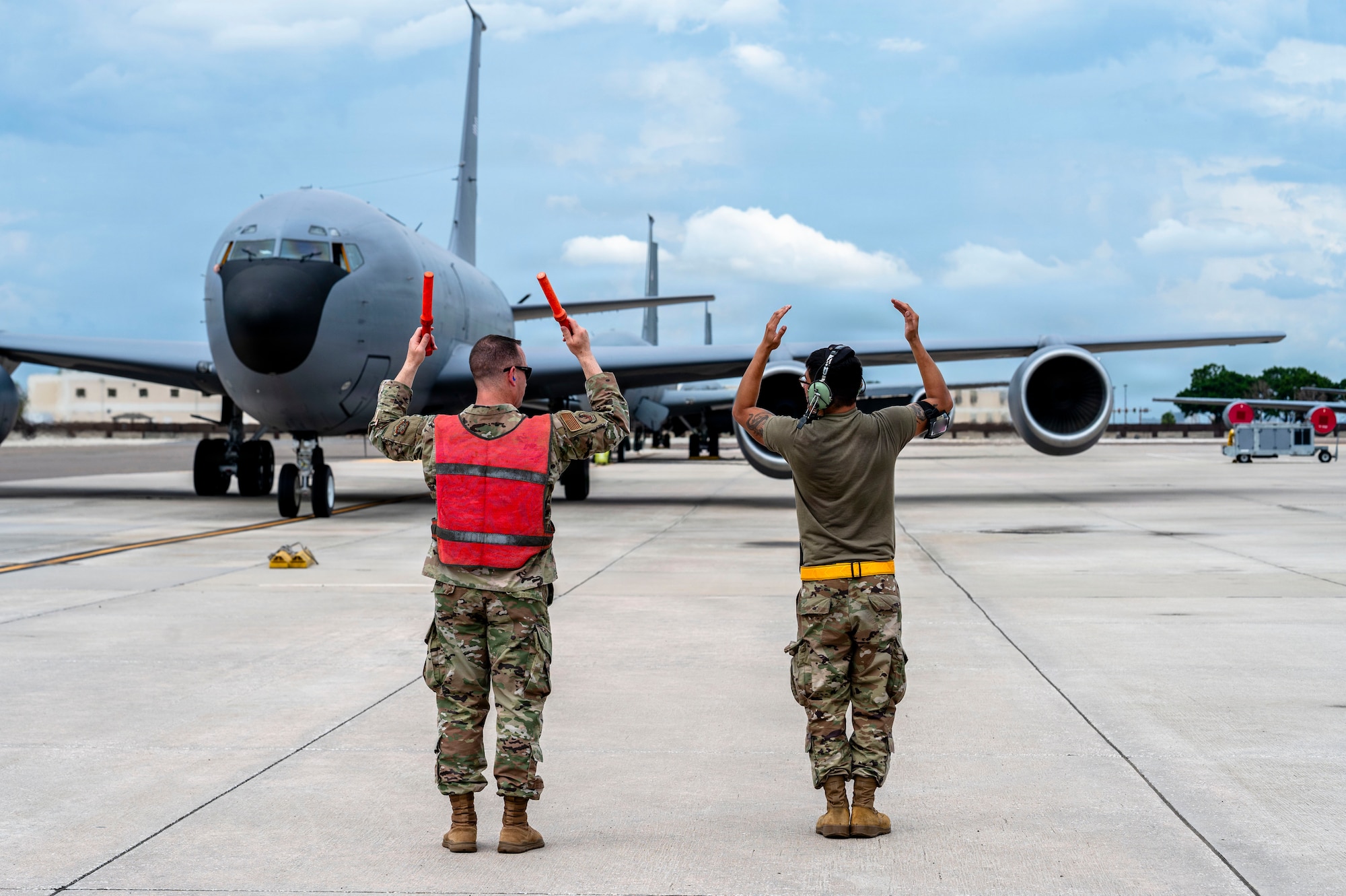 U.S. Air Force Chief Master Sgt. Christopher Ottenwess, 6th Air Refueling Wing command chief, marshals in a KC-135 Stratotanker assigned to the 6th ARW alongside a 6th Aircraft Maintenance Squadron Airman during a redeployment at MacDill Air Force Base, Florida, July 3, 2026. The redeployment marked the return of Airmen following the completion of their deployment in support of global operations. (U.S. Air Force photo by Senior Airman Monique Stober)