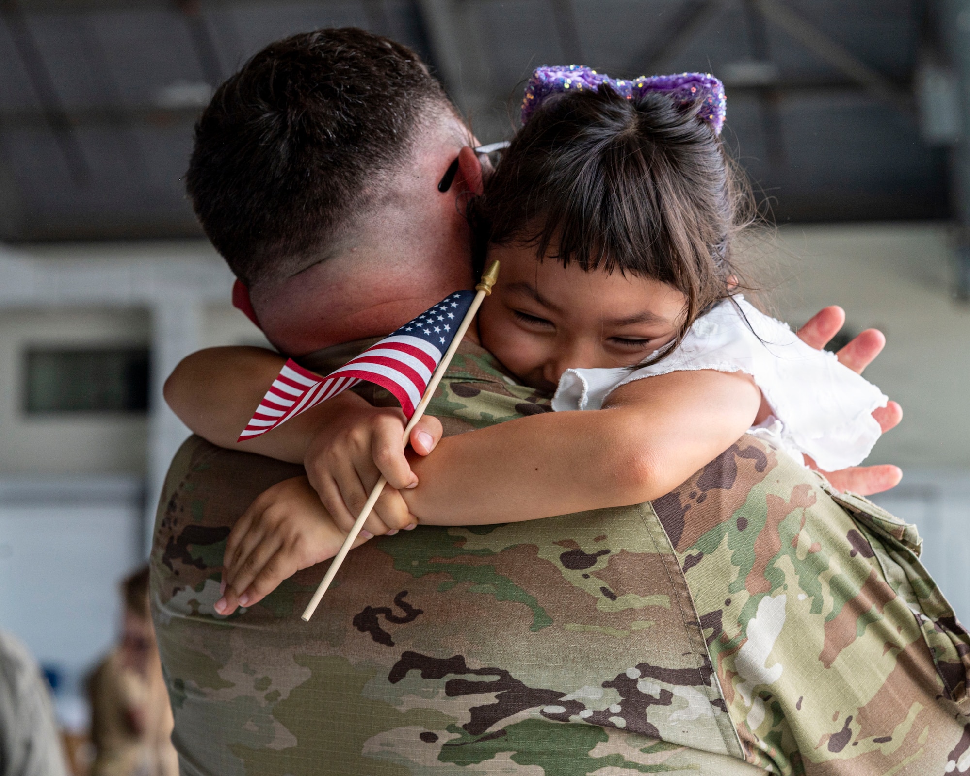 U.S. Air Force Senior Master Sgt. Lance Green, 6th Aircraft Maintenance Squadron fabrication flight superintendent, embraces his daughter during a redeployment at MacDill Air Force Base, Florida, July 3, 2026. Homecomings like these highlight the resilience and unwavering support of military families, whose sacrifices help sustain the 6th Air Refueling Wing's global mission. (U.S. Air Force photo by Senior Airman Monique Stober)