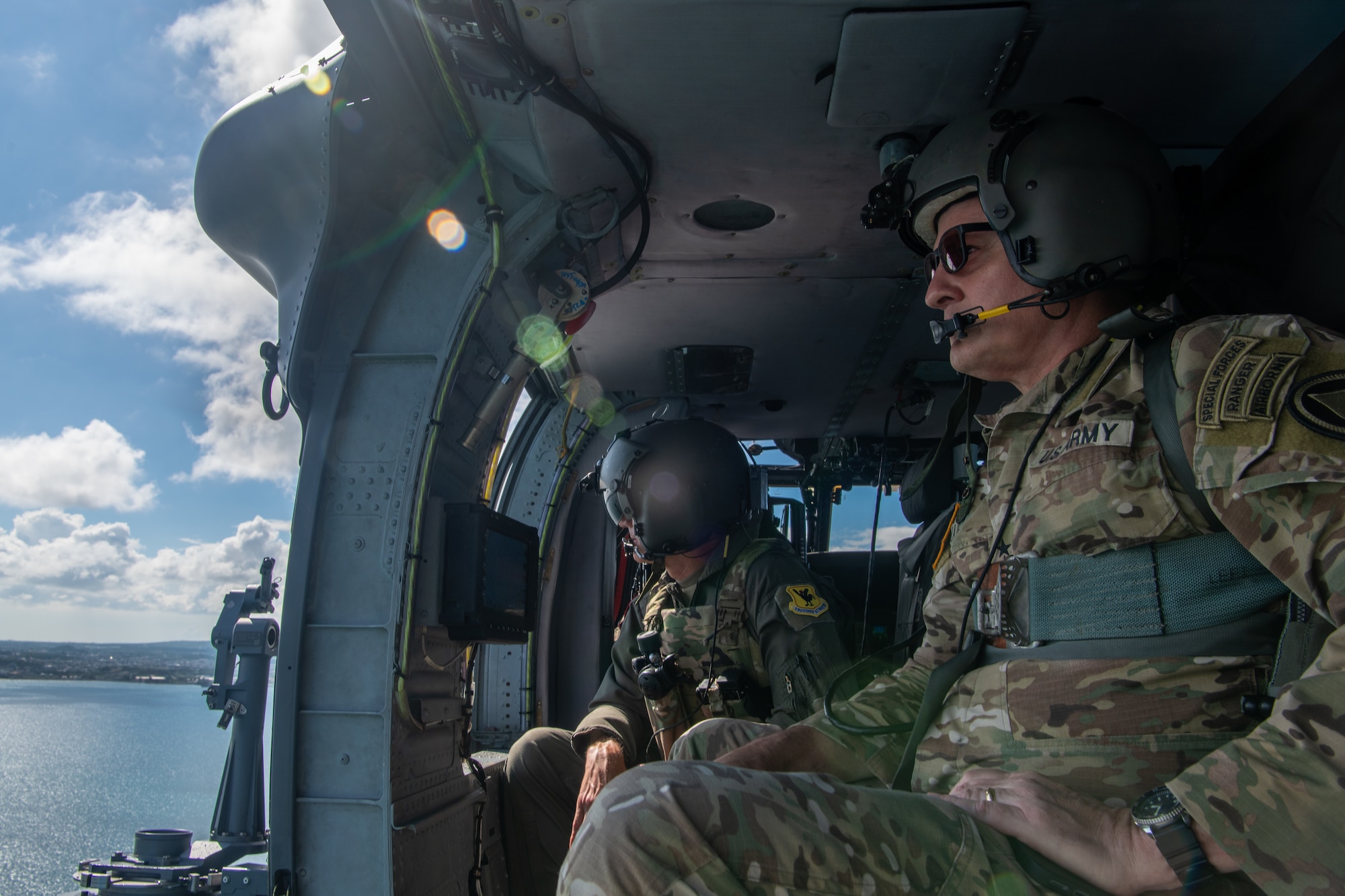 U.S. Air Force Brig. Gen. John Gallemore, left, 18th Wing commander, flies with U.S. Army Lt. Gen. Steven Marks, vice commander of U.S. Special Operations Command and director of the Defense Autonomous Warfare Group, during an HH-60W Jolly Green Il flight over Kadena Air Base, Japan, July 23, 2026. The engagement highlighted Kadena’s operational capabilities and reinforced the installation’s role in sustaining combat power and readiness across the Pacific. (U.S. Air Force photo by Senior Airman Melany Bermudez)