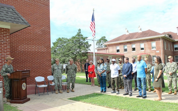 Rear Adm. Robert Hawkins, commander, Naval Medical Forces Atlantic (NMFL) and director, Defense Health Network (DHN) Atlantic, delivers remarks during a ribbon-cutting ceremony for the newly renovated Industrial Hygiene headquarters at Naval Support Facility Indian Head, Aug. 4. The project transformed a historic 1918 building—originally constructed as a base firehouse and later used as a chapel—into a modern workspace. This critical transition successfully ends more than 30 years of the industrial hygiene team operating out of a deteriorating and highly deficient temporary trailer, providing staff with a permanent, professional facility to safeguard base personnel and ensure long-term mission success.