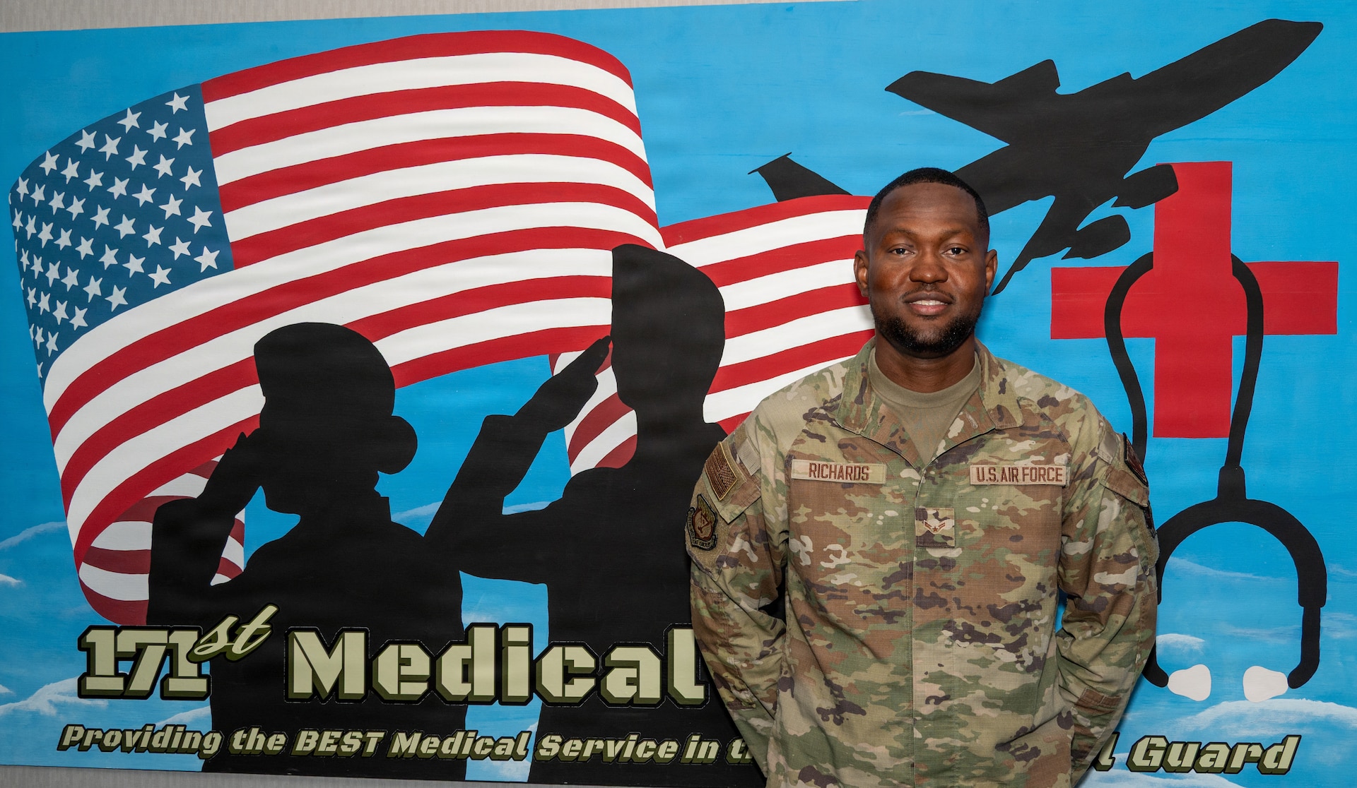 Airman 1st Class Byron Richards, an aerospace medical technician assigned to the 171st Air Refueling Wing, Pittsburgh, Pennsylvania, poses in front of a medical mural on base for an airman spotlight Aug. 5, 2026. (U.S. Air Force National Guard photo by Tech. Sgt. Rebecca Wirth)