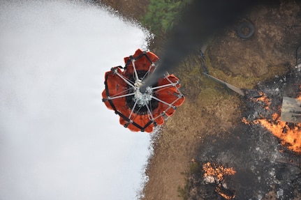 A Washington National Guard helicopter bucket dumps water on the Autumn Lane Fire near Spokane, Washington, August 4, 2026.