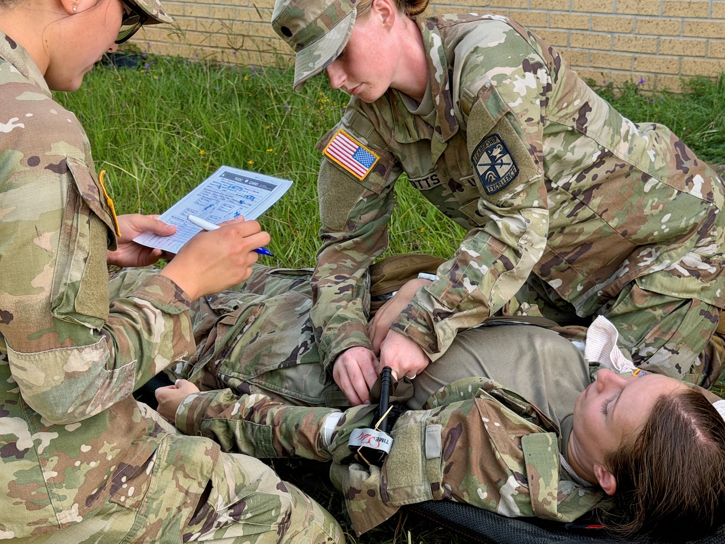Nursing Cadet practices putting a torniquet to a patient as a proctor observes.